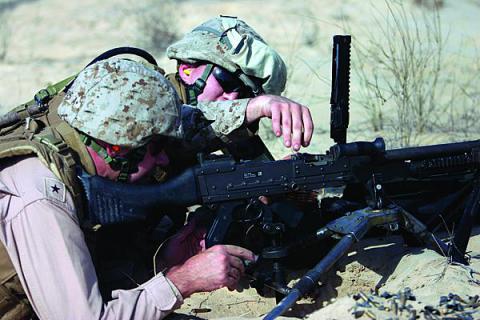 A U.S. Marine Corps sergeant shows then-Rear Adm. Kendall Card, USN, commander, Expeditionary Strike Group 3, how to load the M-240B machine gun during Adm. Card’s visit with the 26th Marine Expeditionary Unit during a 2008 training exercise.