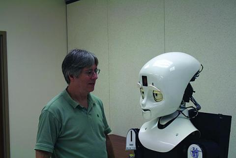 LASR director Alan Schultz engages one of the lab's humanoid robots in the Prototyping High Bay.