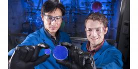 Sandia National Laboratories researcher Patrick Feng (l), holds a trans-stilbene scintillator and organic chemist Joey Carlson holds a scintillator made of organic glass.