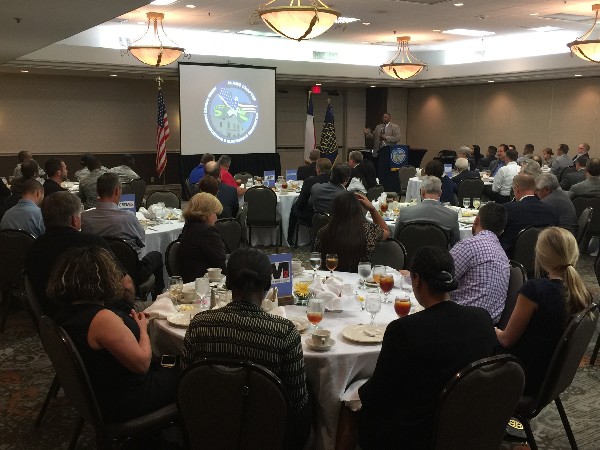 David Colbert, principal contracting officer, Defense Health Agency, speaks to attendees about contracting at the chapter's July luncheon.