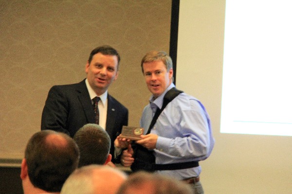 Thele (l) accepts a token of appreciation from Morrow following his luncheon presentation in February.