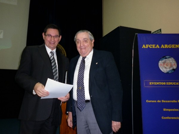 Rear Adm. Emilio Nigoul, ARA (Ret.) (r), chapter president, presents a certificate of recognition to Miguel Pesado, ARSAT manager, who spoke at the chapter's course in August.