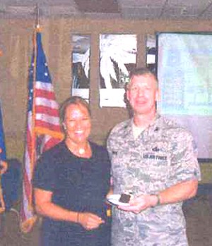Heidi Hughes, chapter president, presents guest speaker Col. Jay Bruhl, USAF, Air Force Technical Applications Center, Patrick Air Force Base, Florida, with a token of thanks for his presentation at the September meeting.
