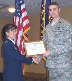 Col. Rogers (l) presents a certificate of recognition to 
Capt. Billy Myers, USAF, AFTAC, as Outstanding Company Grade Officer of the Year at major command level during the March meeting.
