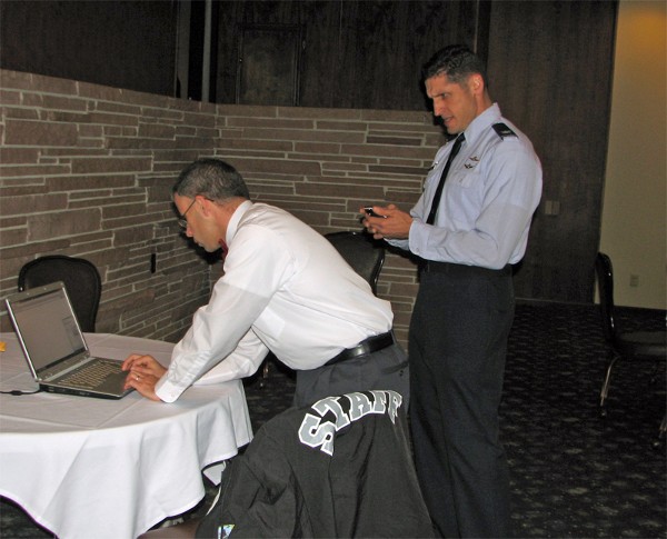 Matthew Ginnaty (l), chapter vice president for membership, and Col. Routsis take on final preparations for the chapter's holiday mixer in December to facilitate participants establishing their membership with AFCEA International.
