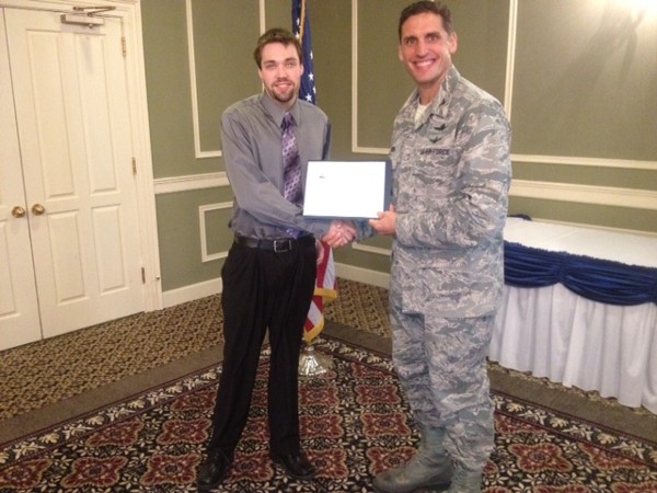 John Sand (l), a student at the University of Nebraska at Omaha, and Col. Routsis shake hands.  Sand received one of the chapter's scholarships for $1,000. He is pursuing a bachelor of science degree in management information systems.
