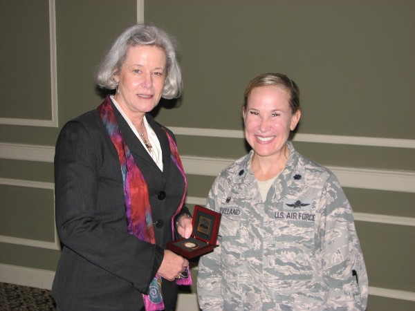Chapter President Lt. Col. Sarah Cleveland, USAF (r), presents September luncheon speaker Patricia Tracey, vice president, homeland security and defense, U.S. public sector, enterprise services, Hewlett-Packard (l), with a chapter coin. 
