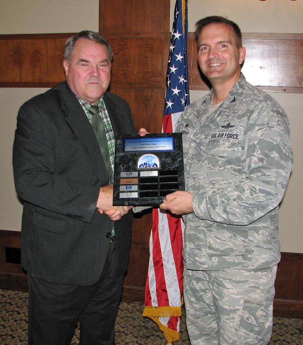 Chapter President Col. Sean Murphy, USAF (r), congratulates Sonny Ashford, director of business development and marketing, Software Engineering Services (SES), Bellevue, Nebraska, who accepts the Carpino Collaborative Team Excellence Award at the June State of the Chapter luncheon. The award recognizes a program sponsor that best demonstrates volunteerism, participation, initiative and citizenship in support of the chapter over the program year.