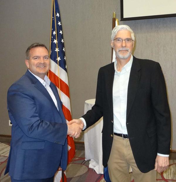 Sean Murphy, chapter president stand-in (l), shakes hands with Douglas Rausch (right), director, Cybersecurity Education, and program director for Undergraduate and Graduate Cybersecurity Programs, Bellevue University, Bellevue, Nebraska. Rausch was the speaker for the April luncheon and received a Greater Omaha Chapter coin for addressing the chapter.