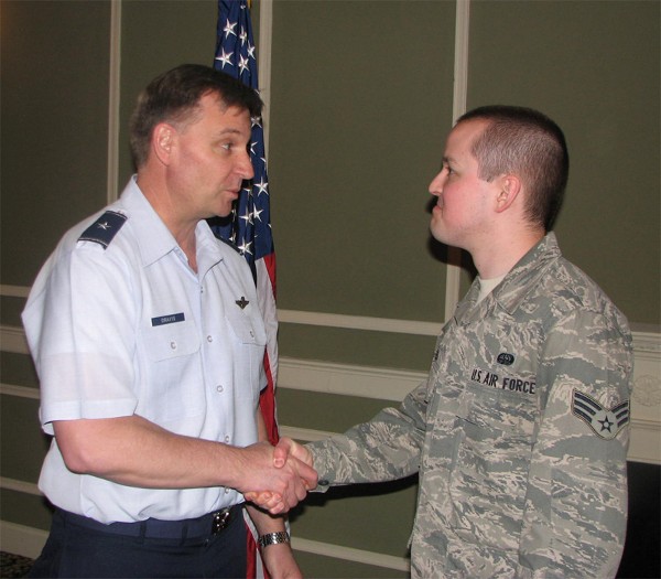 Gen. Dravis (l) shakes hands with Senior Airman Christopher Voss, USAF, lead Young AFCEAN, who received a JTSO coin at the chapter’s March luncheon.