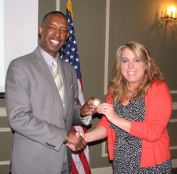 Randy White (l), director, 55th Wing, Equal Opportunity, Offutt Air Force Base, shakes hands with Lexi Eker, chapter assistant diversity liaison. White received a chapter coin for addressing the chapter at the May luncheon on how individual experiences are unique and help formulate perceptions of others.