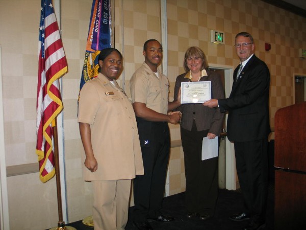 Teresa Duvall (2nd from r), chapter president, presents the chapter's December Military Cyber Professional Award to Petty Officer 3rd Class Frankie Langford, USN (2nd from l), Naval Computer Telecommunications Area Master Station, Atlantic. Senior Chief Petty Officer Latrina D. Tate, USN, and Doug Vanderlip, chapter executive vice president, stand witness.