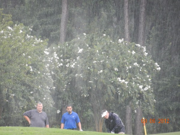 Jack Kasiski, vice president, URS Platform Readiness and Technology Support; Ahmad Mojaddidi, program manager, URS Systems Engineering and Information Solutions Group; and Brian Hinkley, vice president, URS EMS Operations, play through the rain at the chapter's September charity tournament.