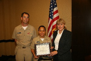 Cdr. Angie Albergottie, USN (c), director of the office of compliance and assessment, Naval Network Warfare Command, receives the Military Information Professional of the Month award for October from Teresa Duval, chapter president. Capt. Douglas Swanson, USN, nominated Cdr. Albergottie for the award.  