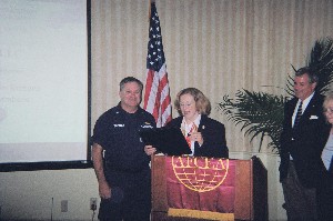 Cmdr. Gary M. Thomas, USCG, receives the chapter's AFCEAN of the Month award for April from Dasha Little, chapter awards committee chairman.
