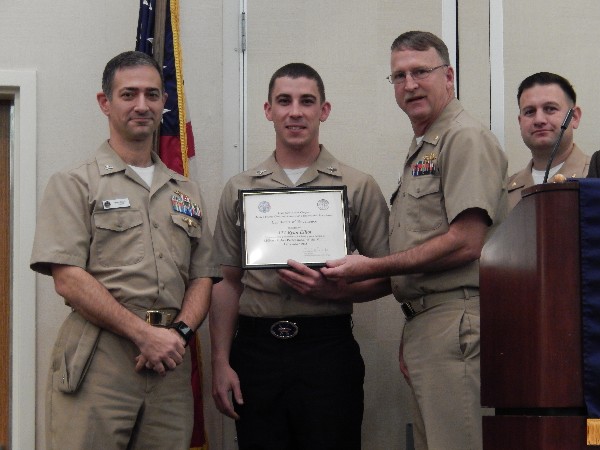 Capt. Mark Guzzo, USN (l), assistant chief of staff for the C41 Carrier Strike Group; Lt. Cmdr. Doug Vanderlip, USN (2nd from r), chapter president; and Lt. Cmdr. Dave Pereira, USN (r), Young AFCEAN chair, present the December Military Cyber Professional of the Month Award to Information Systems Technician 1st Class Ryan Elliot, USN.