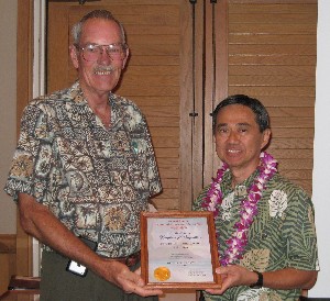 Adm. Dick Macke, USN (Ret.) (l), chapter president, presents the chapter's Executive of the Month award to Art Nakagawa, Space and Naval Warfare Systems Command.