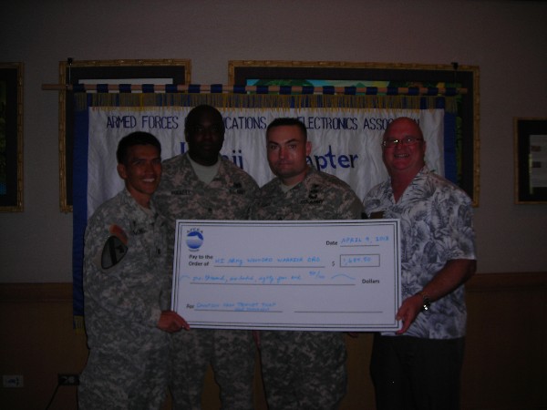 Ed Ryglewicz (r), regional vice president, presents proceeds raised from the chapter’s annual golf tournament to representatives of the Hawaii Army Wounded Warrior Organization in April.