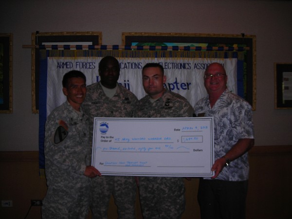 Ed Ryglewicz (r), regional vice president, presents proceeds raised from the chapter's annual golf tournament to representatives of the Hawaii Army Wounded Warrior Organization in April.