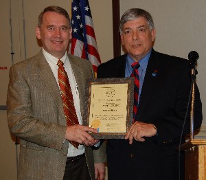 Dr. Marcus J. Bendickson (l), Dynetics Inc., receives a corporate membership certificate from Vic Budura, chapter vice president for programs, in April.