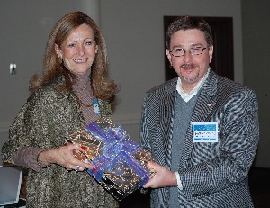 Darren Brewer, chapter treasurer, presents a door prize to Jeariene Bacon, chapter member, at the Member Appreciation Social, held in January.