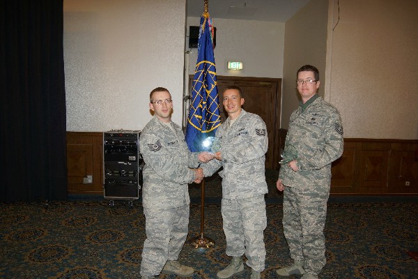 Tech. Sgt. Eric Trombley, USAF (l), 693rd Intelligence Support Squadron presents Tech. Sgt. Scott Zabel (c), USAF, and Tech. Sgt. Ira Begley, USAF, both of the 1st Air and Space Communications Operations Squadron, with their award for earning first place during the chapter’s first HACKINT competition in October.