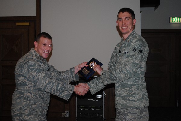 Senior Airman Douglas Clark, USAF (r), receives the Young AFCEAN Emerging Leader of the Month Award from 2nd Lt. Jason Loomis, USAF, during the February luncheon.