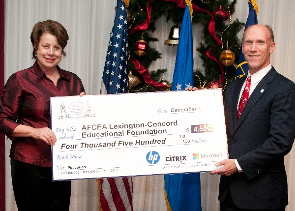 At the December holiday party, Cynthia Hanssan, HP, presents a $4,500 check from HP, Citrix and Microsoft to Vasquez for chapter's education fund.
