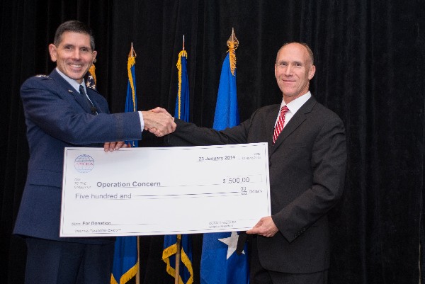 Vazquez presents $500 check in January to Lt. Gen. C.D. Moore II, USAF, commander, Air Force Life Cycle Management Center, for Hanscom Air Force Base’s Operation Concern.