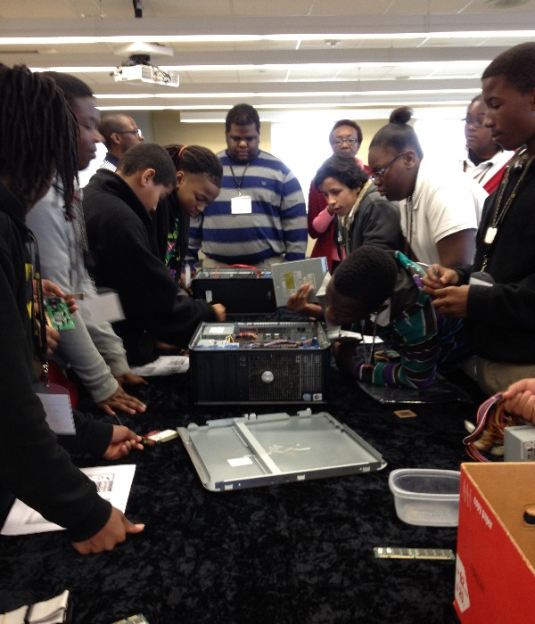 Students disassemble a computer during a hands-on PC assembly workshop at Camp IT in February.