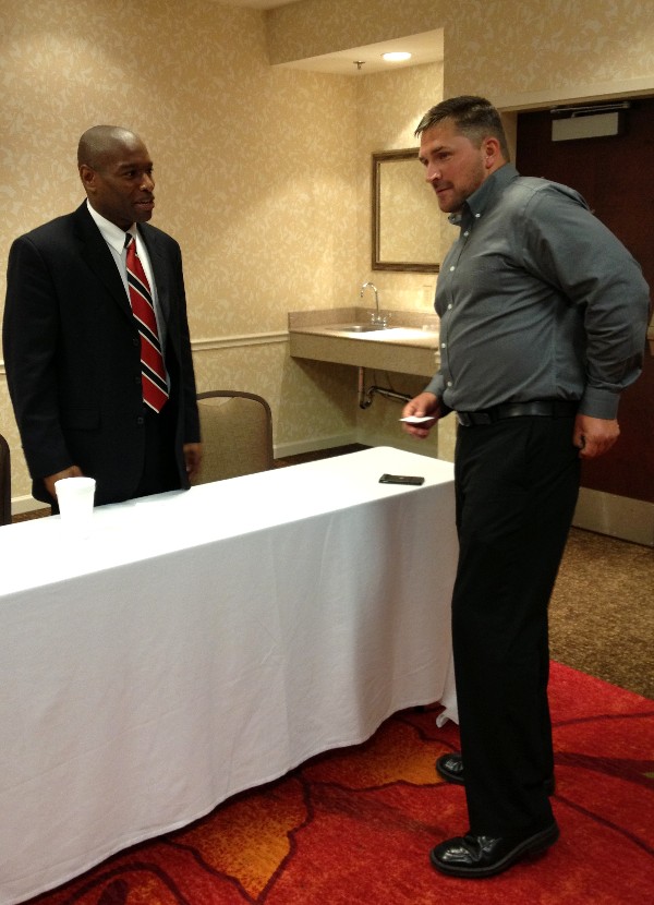 Sloan (l) networks with an attendee at the May Business Over Breakfast event.