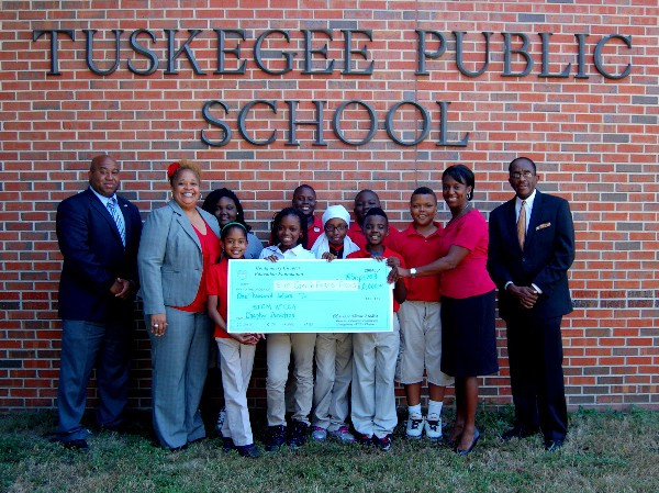 Dr. Erinn Camille Fears Floyd (2nd from l) accepts a $1,000 STEM Teaching Tools Grant presented by Charisse Stokes (2nd from r), director, chapter Education Foundation, in September. Also present are Dr. Kenneth Oliver (far l), program director, Special Education Program, Macon County Board of Education, and Joseph Asberry (far r), principal, Tuskegee Public School, as well as local students.