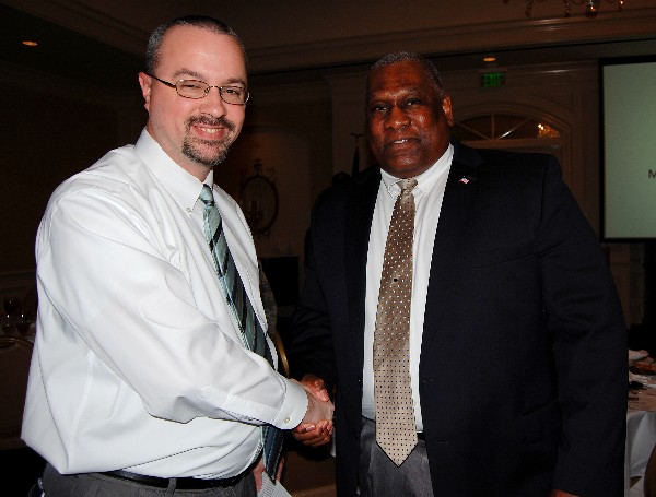 Herbert Hunter (r), director, Business Enterprise Division, Business and Enterprise Systems Directorate, Maxwell Air Force Base-Gunter Annex, shakes hands and networks with a luncheon attendee following his presentation in February.