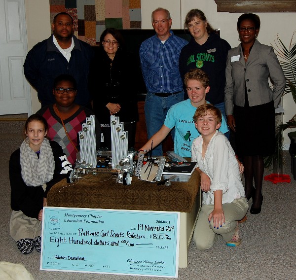 The Prattville Girl Scouts Robotics team proudly accepts a donation from Charisse Stokes (far r), director of the chapter's Education Foundation, in November.