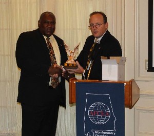 Joe Besselman (r), chapter president, presents an Alabama Clay Eagle to Herb Hunter, Air Force Program Executive Office, Business Enterprise Systems, during the December member breakfast.