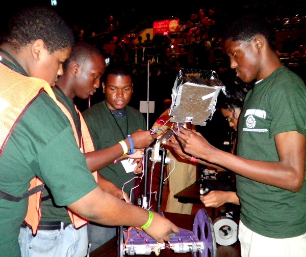 Students of the Macon County Robotics Team put the final touches on their robot during a competition.