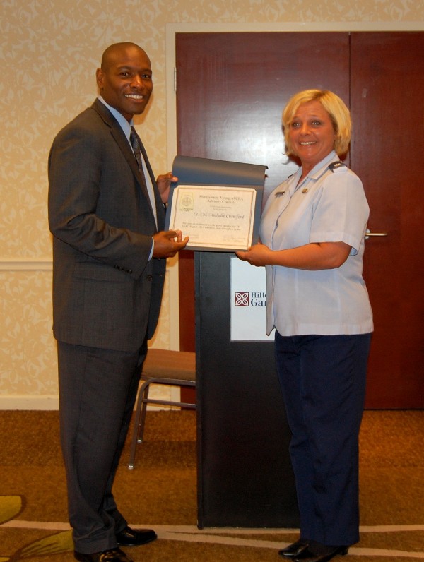 Col. Crawford accepts a certificate of appreciation from Eric Sloan, president of the Montgomery Young AFCEA Chapter, in August.