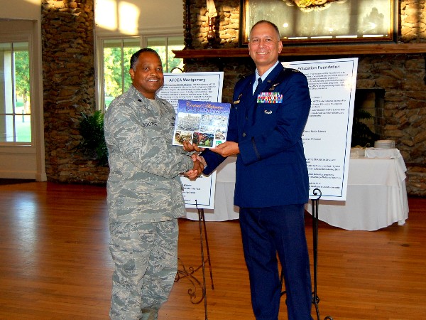 In September, Col. Boothe (l) presents Col. Kjall Gopaul, USAF, chief of the Business Enterprise Systems Operations Division, with a commemorative book as a welcome gift on behalf of the chapter.