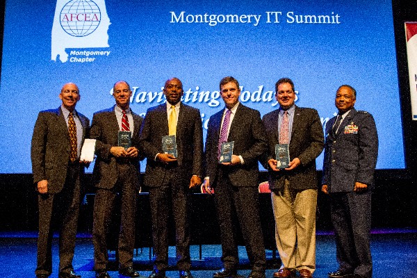 In May, Program Executive Office (PEO) panelists Douglas Wiltsie (2nd from l), PEO, Enterprise Information Systems, Army; Victor Gavin (3rd from l), PEO, Enterprise Information Systems, Navy; Dr. Kenneth Fielding (3rd from r), deputy PEO, Defense Logistics Agency; and Terry Carpenter Jr. (2nd from r), component acquisition executive technical director for Defense Information Systems Agency, accept appreciation plaques from Lt. Col. Leonard Boothe, USAF, (far r), chapter president. Robert Shofner (far l), PEO, Business Enterprise Systems, moderated the panel.