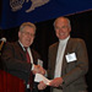 Harry Piccariello (l), chapter president, presents Dr. Lloyd Griffiths with a donation in support of the George Mason University Building Fund during the March meeting.