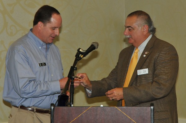 Tony Orlando (r), chapter president, presents Cooley with a 2014 Palmetto Cyber Defense Competition Challenge Coin following his July presentation.
