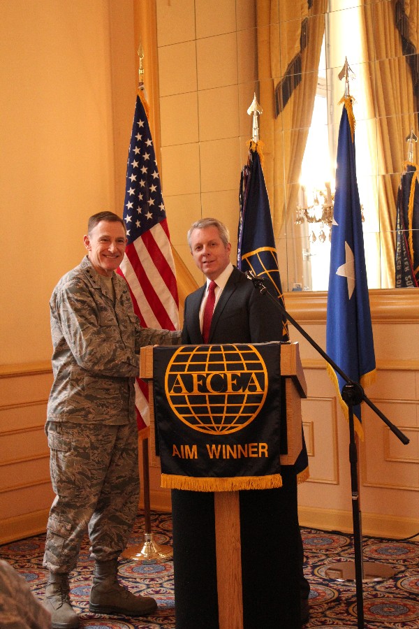 Roger Carpenter, chapter president, presents Lt. Gen. Michael Basla, USAF, chief, information dominance and chief information officer, Office of the Secretary of the Air Force, with a chapter coin to thank him for speaking at the January luncheon.