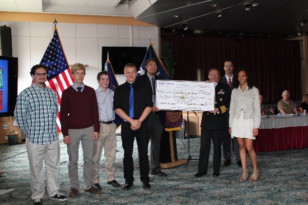 Adm. Martoglio (3rd from r), Tony Walk (4th from r), project manager, GDIT BICES Europe, and Milford (2nd from r) present a $2,500 check, provided by GDIT, to be divided evenly amongst the chapter's scholarship recipients (l-r) Diego Williams, Olaf Bergeson, Matthew Watson, Dylan Rehwaldt, and Morgan Mahlock.