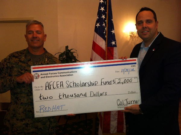 Col. James Turner, USMC, chapter president, receives a donation from a representative of the chapters monthly Title sponsor, Red Hat, at the November luncheon.