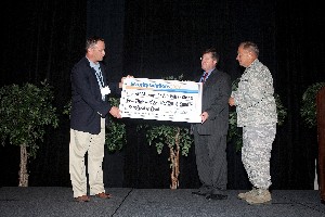 In May, John Wood (l), chief executive officer, Telos Corporation, presents a $5,000 check to Brandt Cosgrove (c), chapter vice president, as Maj. Gen. John W. Maluda, USAF, director, cyberspace transformation and strategy, Secretary of the Air Force Office of Warfighting Integration and Chief Information Officer, looks on. The conference's golf tournament raised funds that benefit the chapter's scholarship programs.