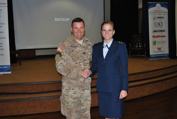Chapter President Col. John McLaughlin, USA, presents a coin to Savannah Wheeler, AFROTC, during the April chapter luncheon to recognize her selection as an AFCEA ROTC Honor Award recipient. Wheeler is a junior majoring in computer science at the University of South Florida.