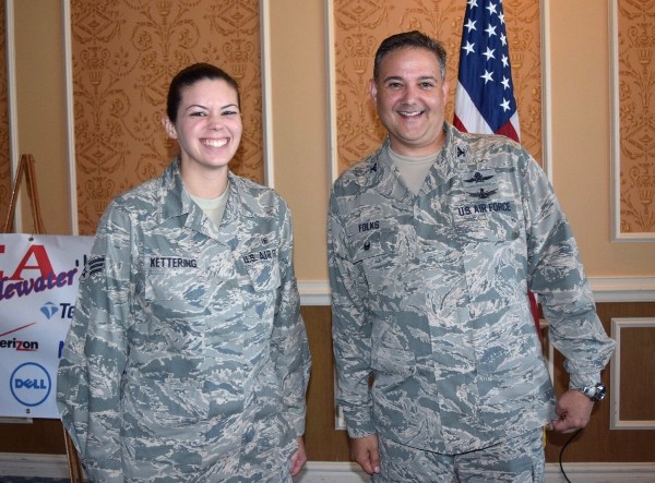 Senior Airman Jessica Kettering, USAF, is presented a chapter presidents coin at the October luncheon by Chapter President Col. Rick Folks, USAF, as the Young AFCEAN of the Month for October for her outstanding support to the chapter. 