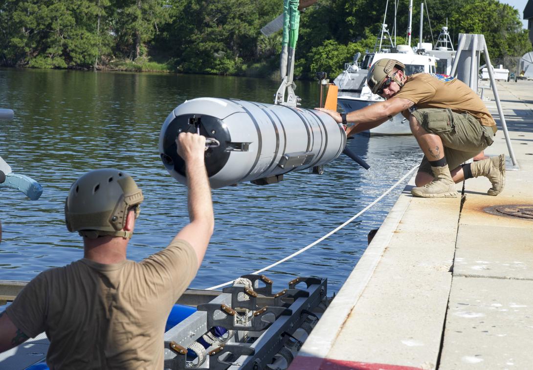 Sailors load an unmanned underwater vehicle onto an inflatable boat during a mine countermeasure certification exercise at Panama City, Florida. Credit: Mass Communication Specialist 2nd Class Charles Oki, U.S. Navy