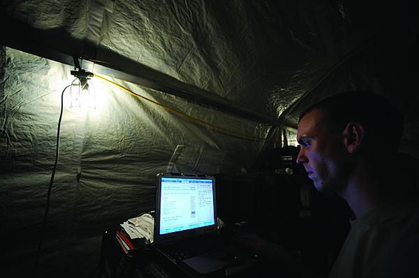 A U.S. Air Force network administrator employs a laptop at Kandahar Airfield, Afghanistan.