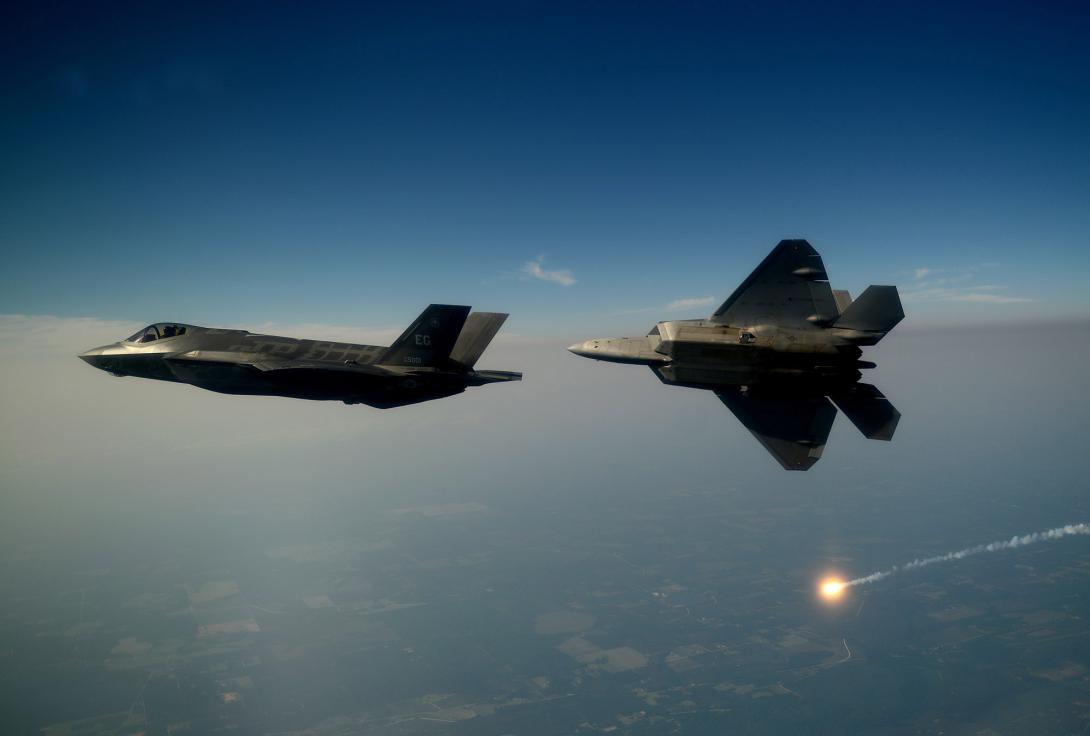 An F-35A Lightning II joint strike fighter and an F-22A Raptor soar over the Emerald Coast. Some nations have reduced the number of F-35s they intend to purchase.